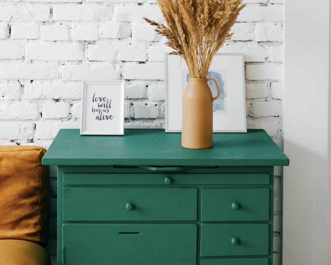 green drawers next to white brick wall